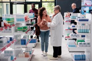 Employers should educate employees regarding pharmacy usage in Indiana Group Health Insurance plans image shows pharmacist helping customer