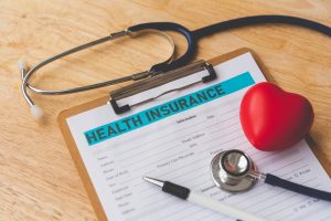 Work with Nefouse & Associates to secure your best Indiana Group Health Insurance deal image shows clipboard and stethoscope